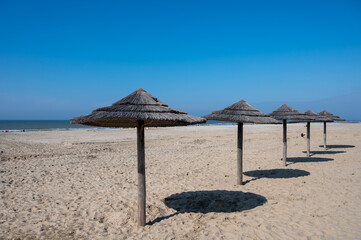 Beach holidays on sandy beach, waterfront relaxation with sun umbrella in Katwijk-on-zee, North sea, Netherlands