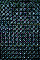 Fototapeta na wymiar Many bottles of champagne sparkling wine. Visit of undergrounds caves, traditional producing of champagne wine in Cote des Bar, Aube, south of Champagne, France