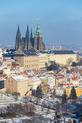 Snowy Prague City with gothic Castle in the sunny Day from the Hill Petrin, Czech republic