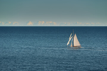 Fototapeta premium Monaco, lonely vintage sail yacht in sea at sunset, huge sail boat, wealth life of billionaires 