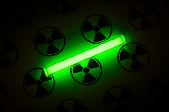 Tritium. Radioactive glow. Gaseous tritium light source in a glass vial. Radiation sign. Green glow hazards to employees, visitors, inspectors. Irradiated zone. Luminous fluorescence, phosphorescence 