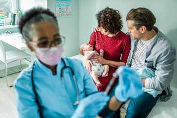 Pediatrician getting ready to vaccinate a newborn baby