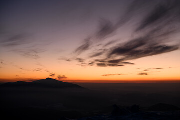Incredible colors of a sunset sky over distant silhouetted mountains