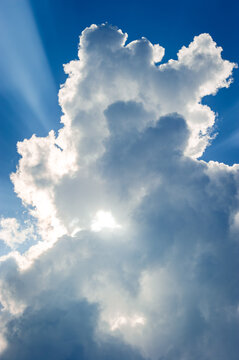 Cloud formations against a blue sky with sun rays 