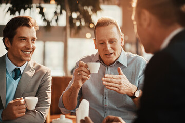 Three businessmen having coffee in a cafe