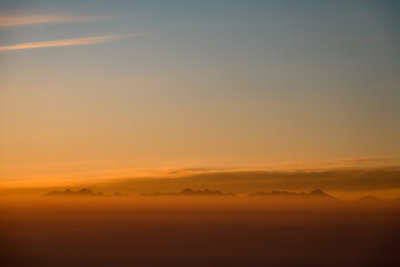 Aerial view on mountain peaks during sunset. High mountain landscape in winter.