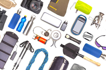 Set of tourist trekking items on white background. Top view of accessories for travel. Equipment...
