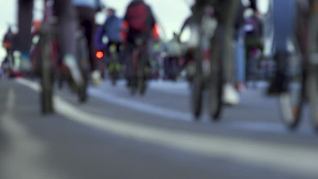 A lot of cyclists are riding on road. Unfocused. Close-up of wheels and pedals. Cycling Festival