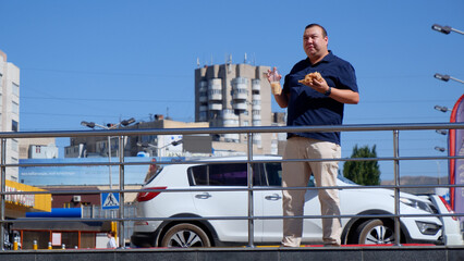 Fat guy eats fast food on the street