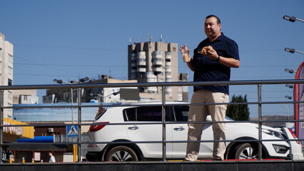 Fat guy eats fast food on the street