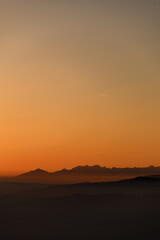 Beautiful view of winter landscape with hills and mountains silhouettes during sunset