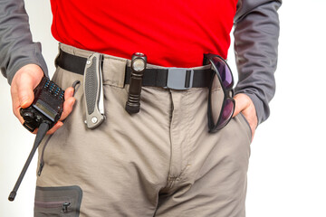 walkie-talkie, flashlight, knife on the belt of the tourist trekking pants. equipment for tourism and travel. EDC items