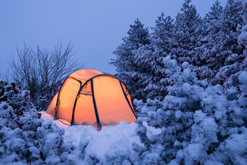 Illuminated tent in a white winter landscape at night