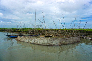 Obraz premium Local people catching fish using large lift net on the river, Net fishing in village river (Veshal jal)