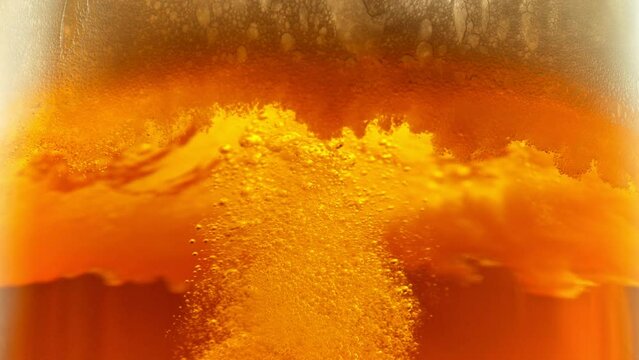 Super Slow Motion Detail Shot of Bubbling and Swirling Fresh Beer in Glass at 1000fps.