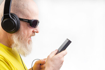 bearded man in sunglasses and headphones listens to music. audio sound style and technology
