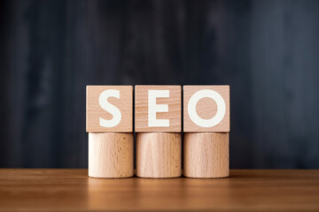 There is wood cube with the word SEO. It is an abbreviation for Search Engine Optimization as...
