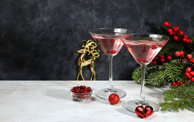 Christmas alcoholic cocktail with red martini, lemonade, champagne in glasses on festive background with fir branches and decorations, bar concept, alcoholic drinks at party,