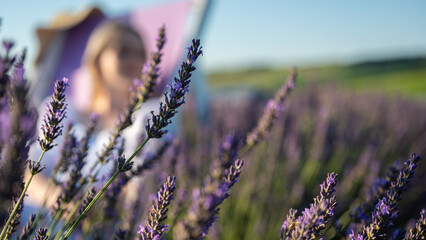 Relaxed young girl in a white dress sitting in a chair, breathing fresh air, sitting in a lavender...