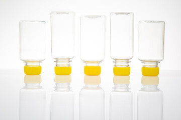 five transparent plastic bottles on a light background