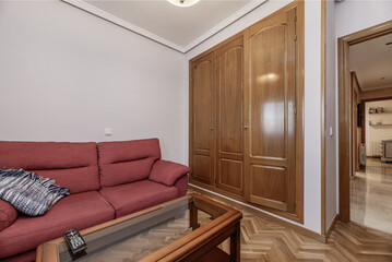 Corner of a living room with a built-in wardrobe with oak doors with wooden coffee table and...