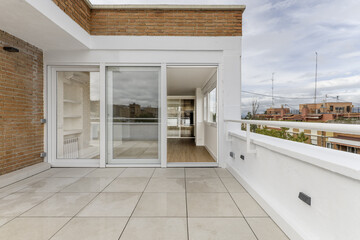 Terrace with white stoneware floor, large window with three aluminum and white glass doors and combined white brick and mud walls
