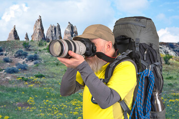 tourist photographer with a backpack photographs the beauty of nature in the mountains. nature hikes in the mountains