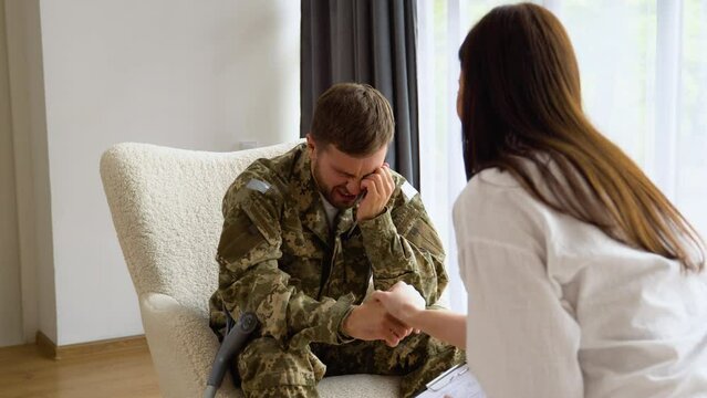 Depressed soldier with ptsd cries during a consultation with a psychologist, selective focus