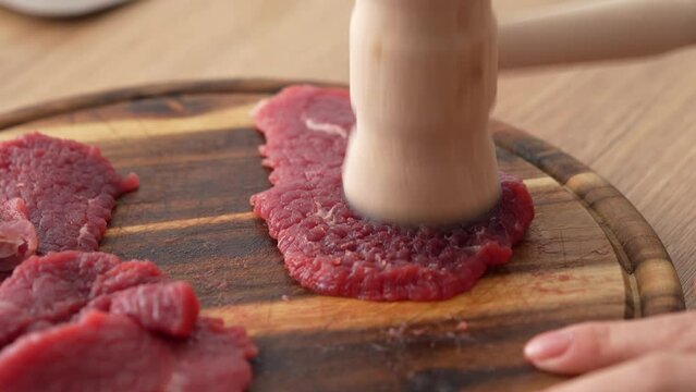 Close-up shot of Tenderizing Beef Steaks on Board.