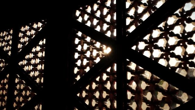 Sun shining through carved window shades close up