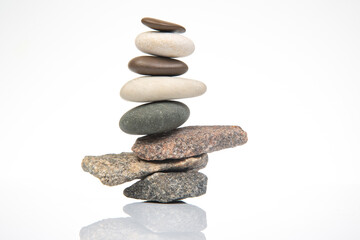 pyramid of stacked stones on a white background. stabilization and balance in life
