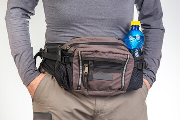Male tourist with a waist bag for things and documents on a trip. belt bag with a zipper for things...