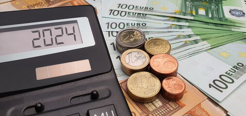 Salary growth in 2024. Calculator on the background of 50 and 100 euro banknotes. Inflation,...