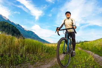 Fototapeta na wymiar bearded man cyclist rides a bike on a road in nature. sports, hobbies and entertainment for health