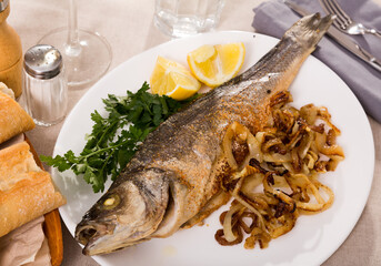 Delicious fish dish - baked sea bass with onion, lemon and parsley