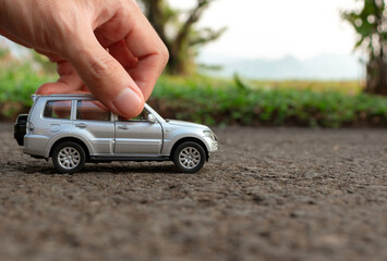 Concept for outdoor activities with toy for children. Photo of a toy car held by hand. After some edits.
