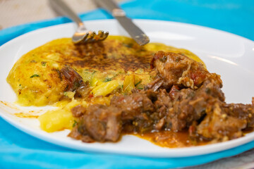 Traditional cassava puree grilled in a pan with pan meat (meat stew)