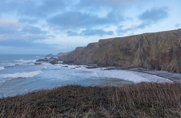 Moody winter seascape with cliffs and waves