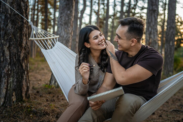 Man and woman young adult couple in nature hold and draw in nature