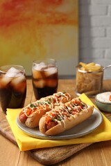 Delicious hot dogs with bacon, carrot and parsley served on wooden table