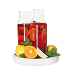 Jugs with tasty punch drink and ingredients isolated on white