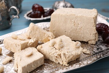 Pieces of tasty halva and peanuts served on vintage tray, closeup