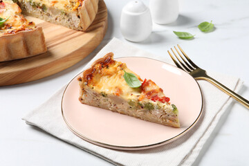 Tasty quiche with tomatoes, cheese and basil served on white marble table, closeup