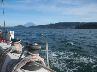 Yachting on Kamchatka, sail ship side with rigging on clew winches and mountains with Koryaksky and...