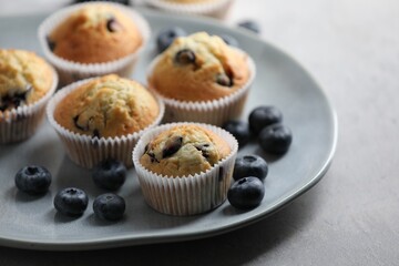 Delicious sweet muffins with blueberries on grey table, closeup