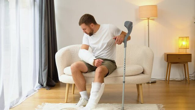 A man with crutch suffer pain from a broken arm and leg