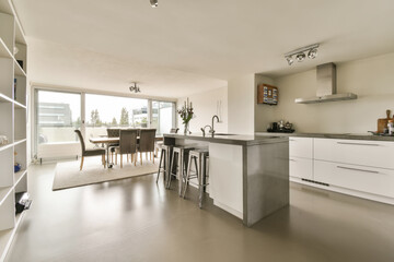 a kitchen and dining area in a modern home with white cabinets, stainless appliances and an island bench on the floor
