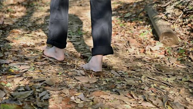 낙엽 쌓인 길을 맨발로 걷고있는 중년 남성. 맨발걷기