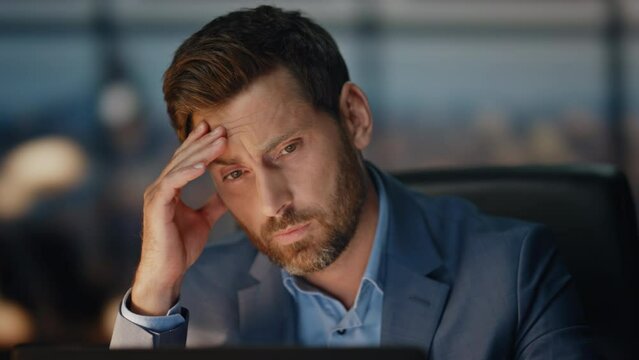 Exhausted manager massaging head at night office closeup. Tired director work