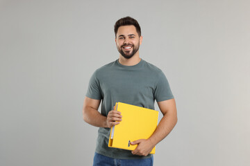 Happy man with folder on light gray background